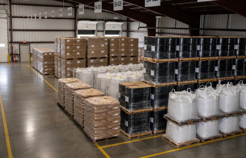 Bulk storage area at the NBN facility with drums, super sacks, and palletized inventory